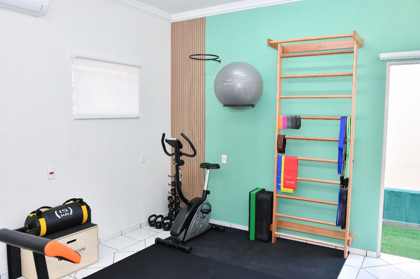 Sala de fisioterapia adulto com bicicleta ergométrica e faixas elásticas