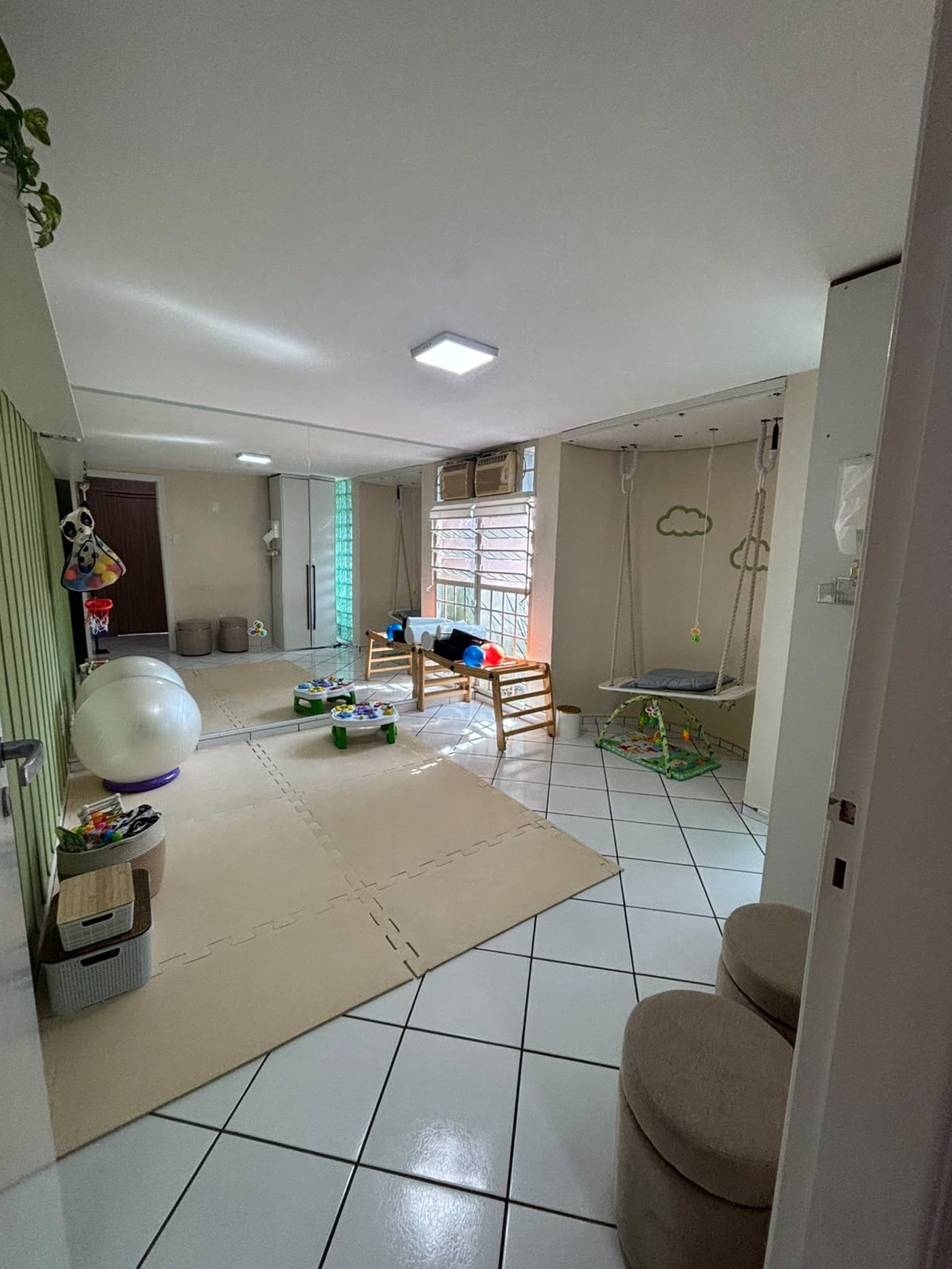Salão amplo do Instituto Vivar, com colchonetes e área lúdica